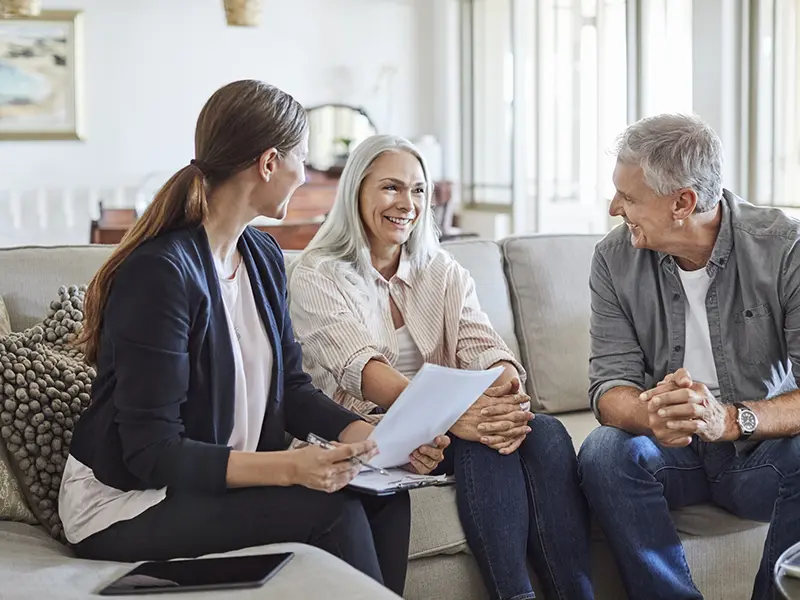 Happy couple with financial advisor at home