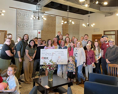 Ent employees presenting a check to the winner