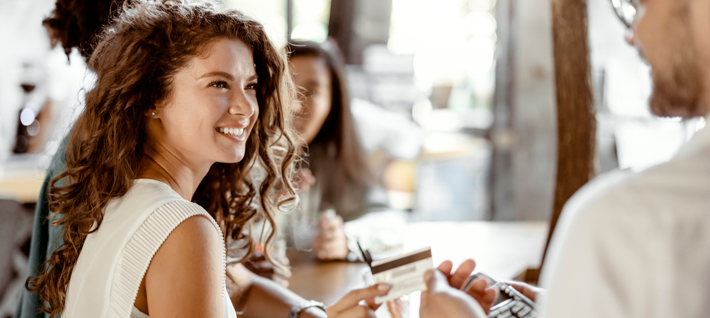 Young women smiling and holding card to pay at the cashiers