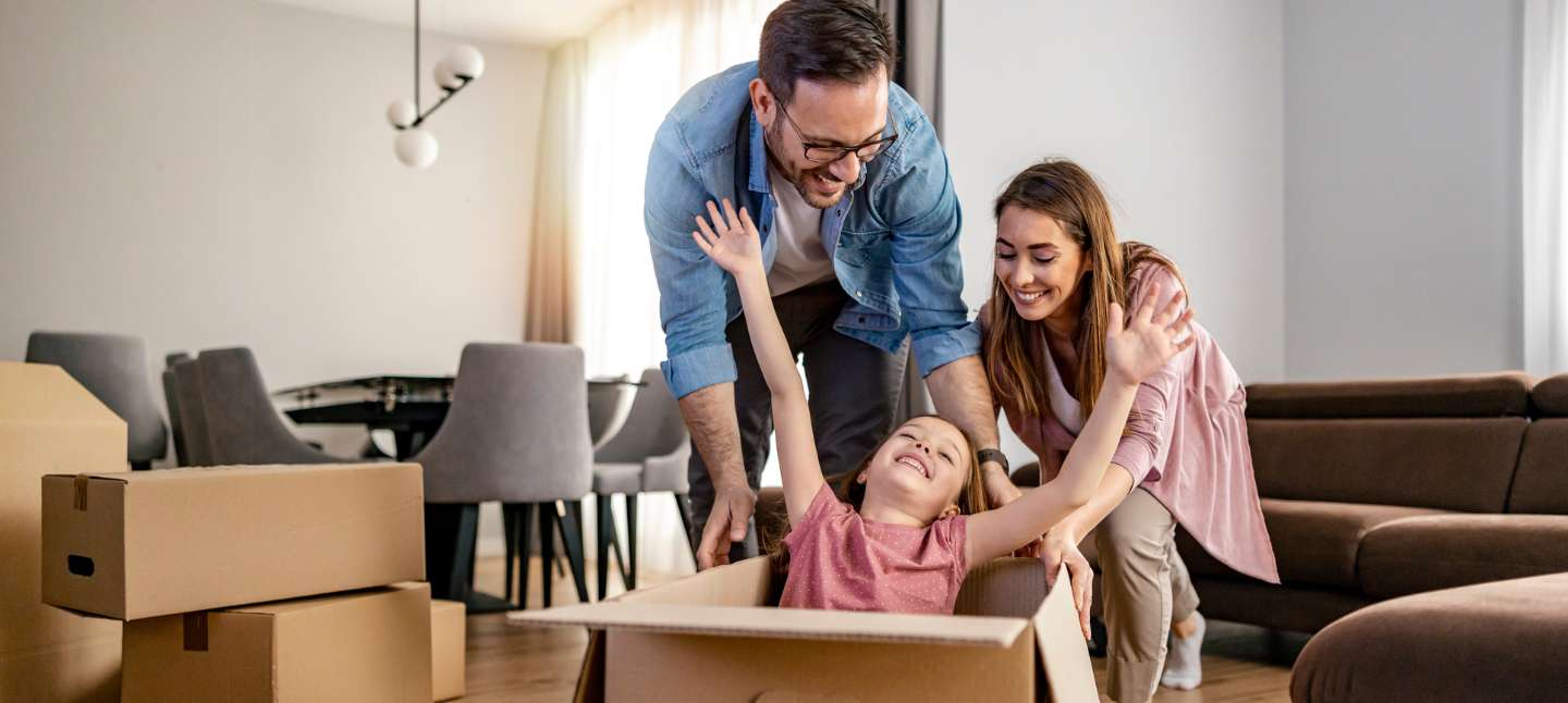 Happy family with cardboard boxes in their new home.