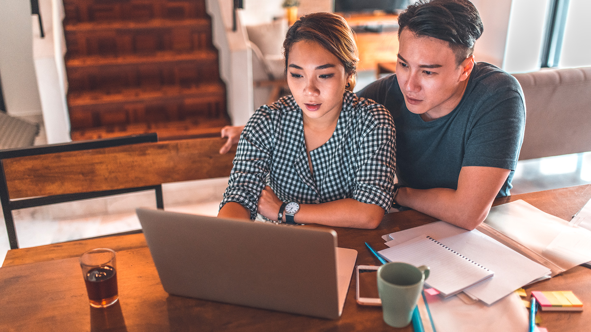 A couple at home using their laptop