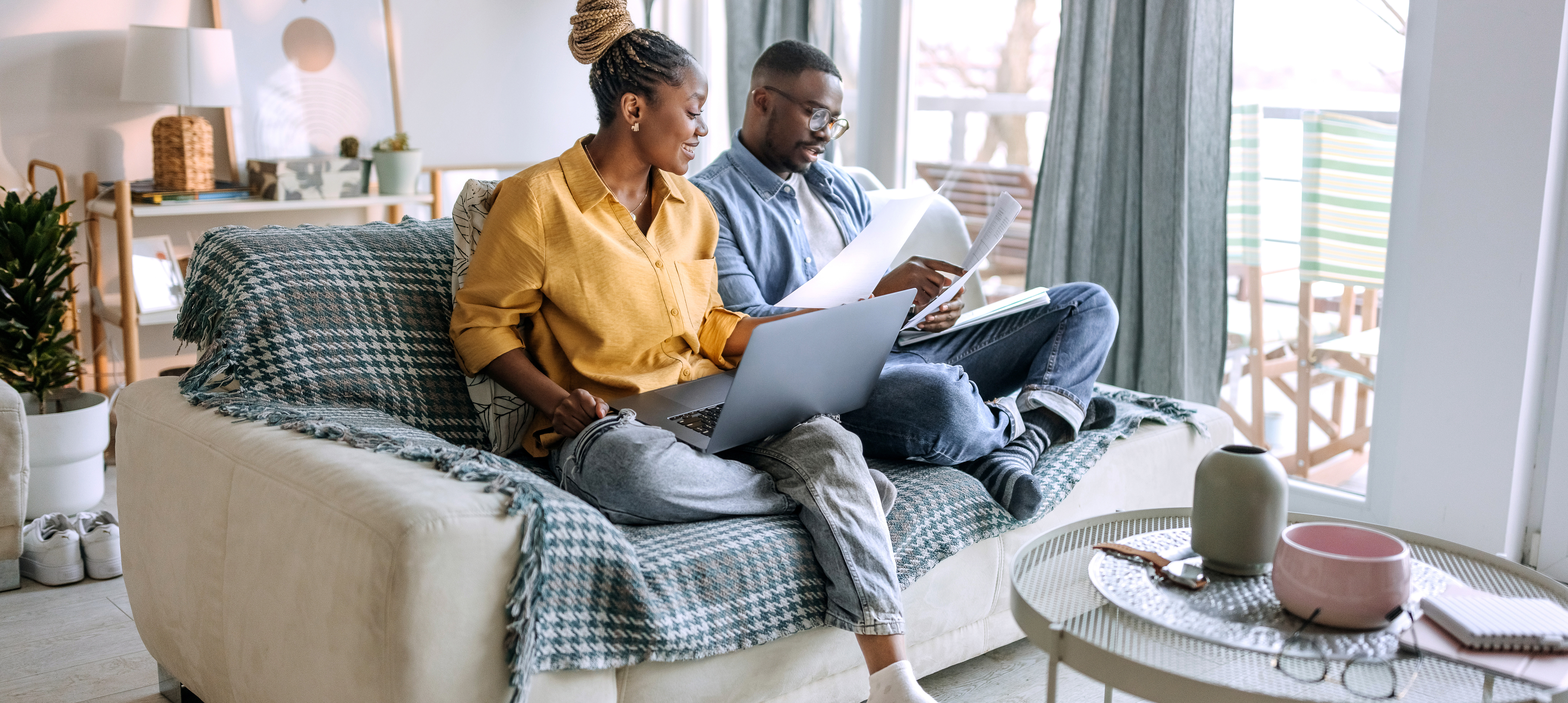 Young smiling couple working from home, going over paperwork