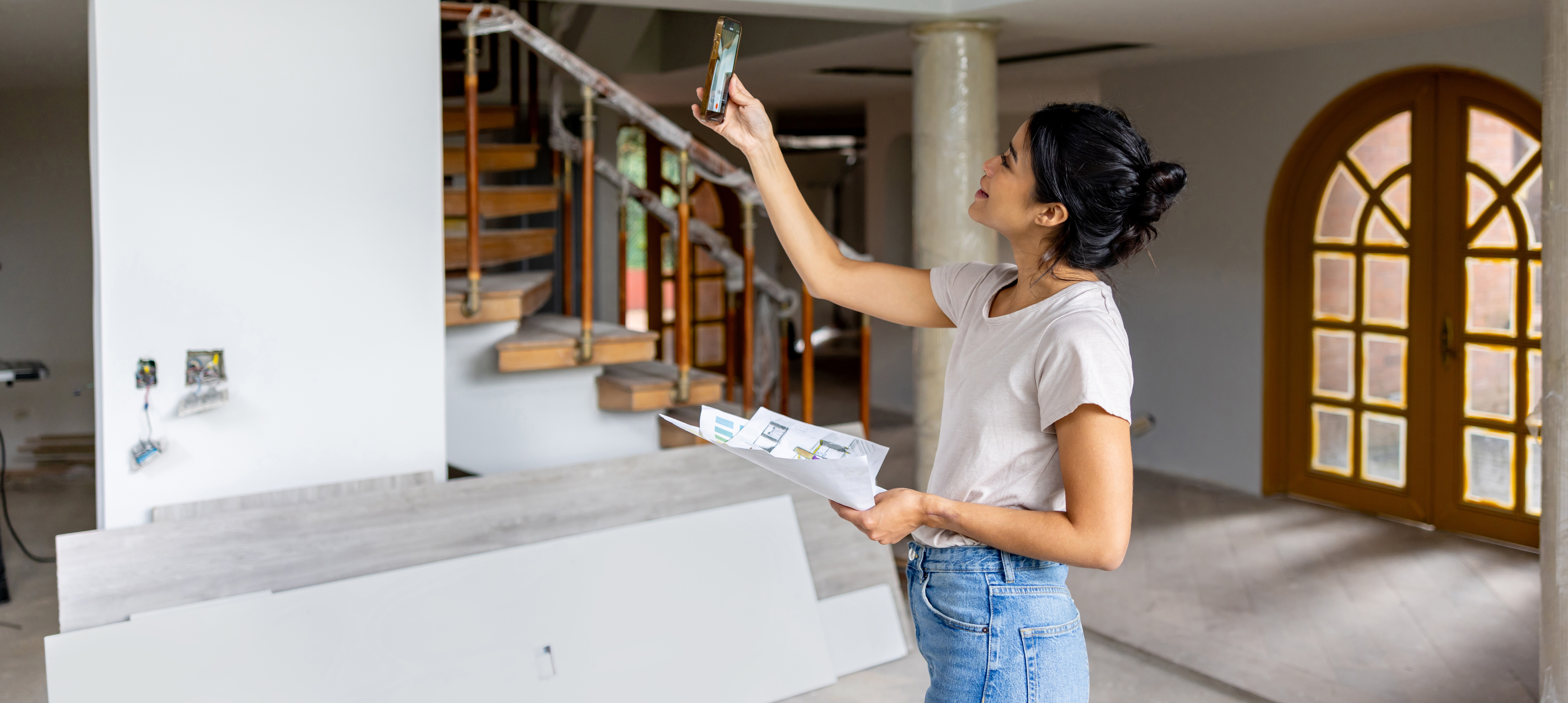 Architect remodeling a house and taking pictures with her cell phone