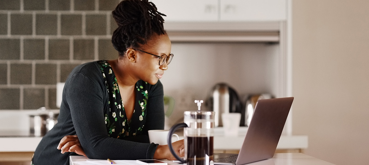 A woman reading some emails in a kitchen