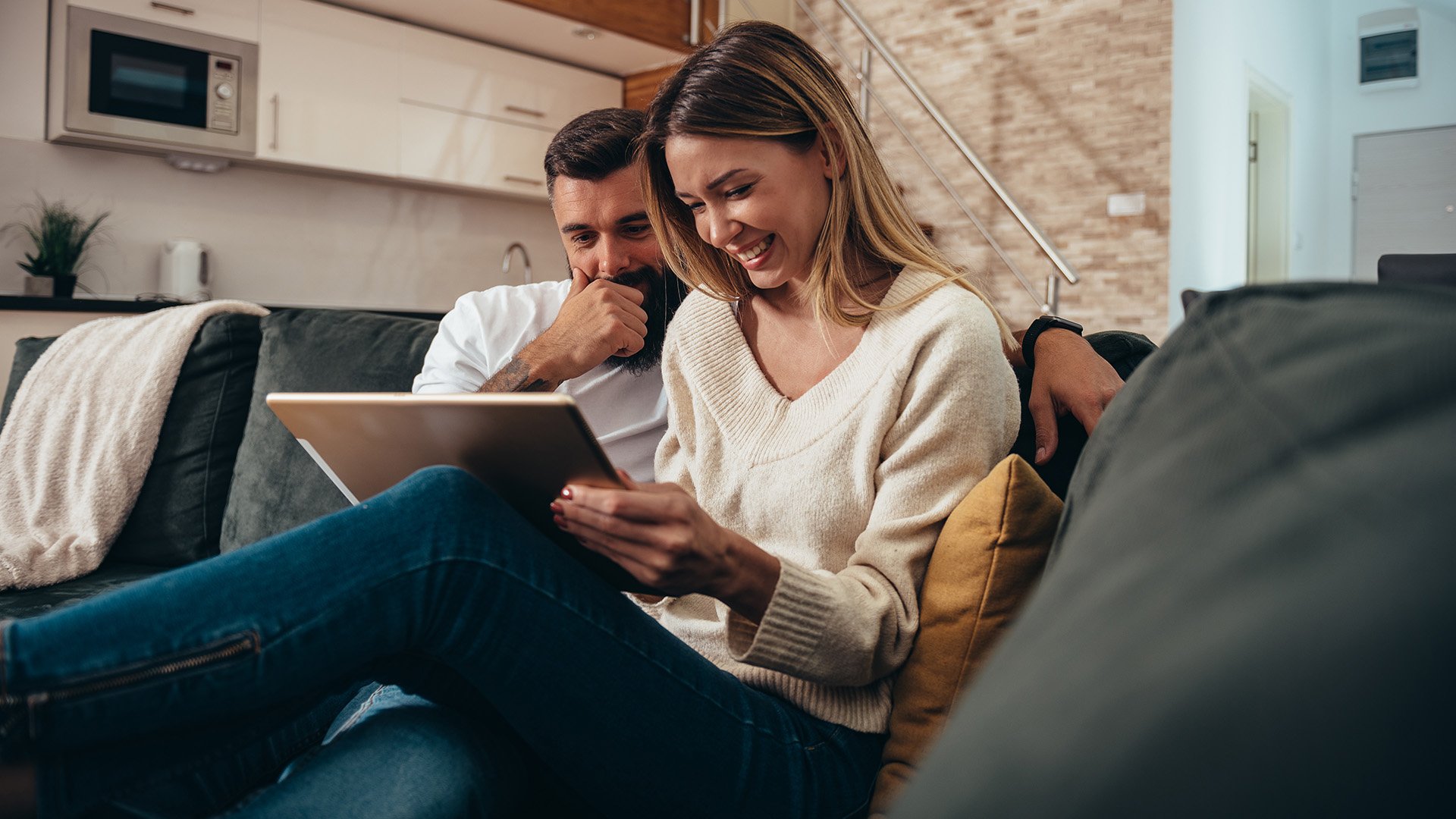 A couple at home using a tablet