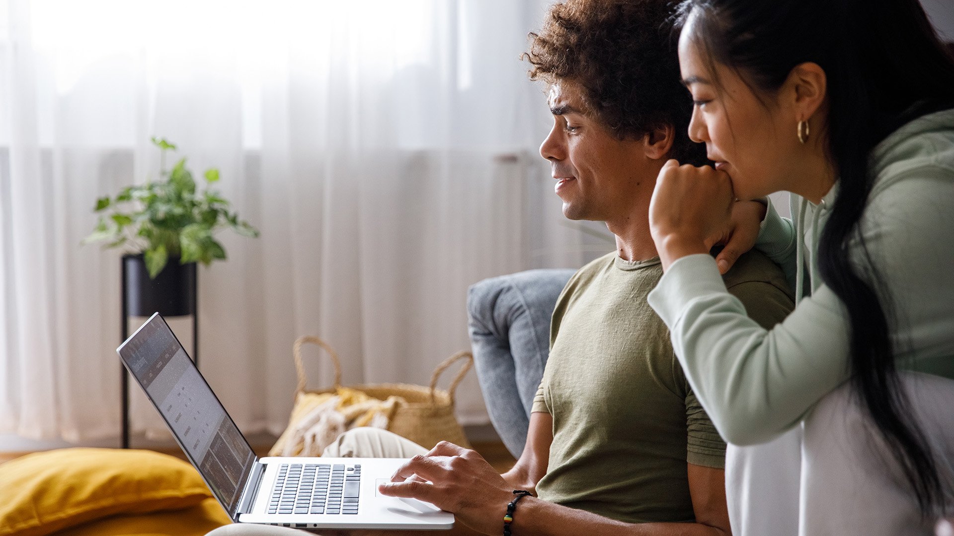A young couple at home on their laptop
