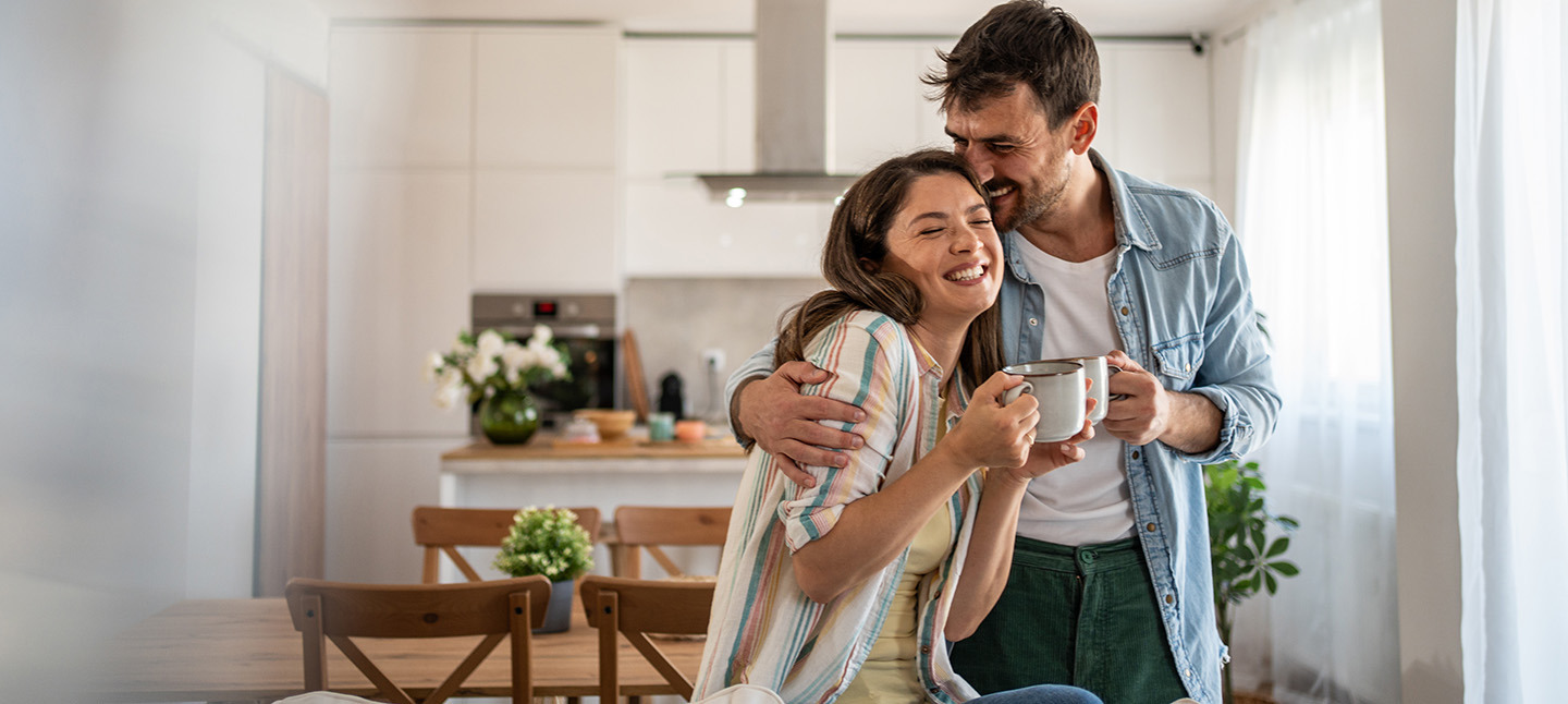 Young couple drinking morning coffee enjoying the weekend in their new home