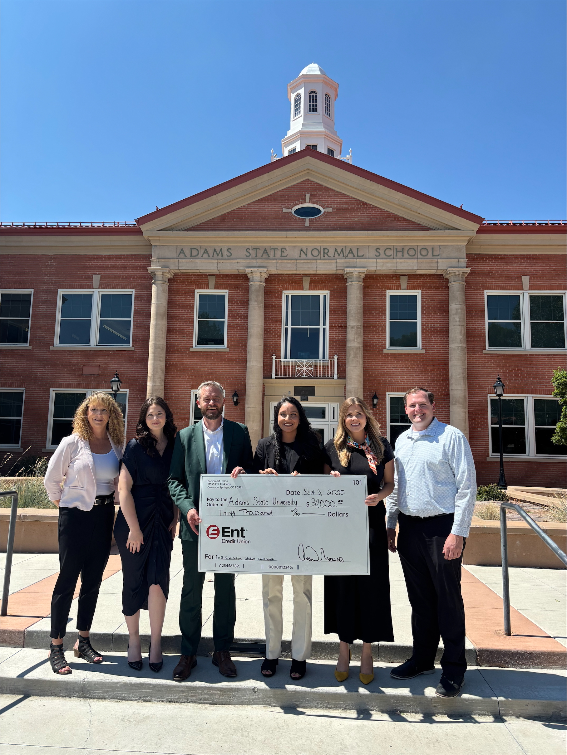 Employees at Ent Credit  present a check to staff at Adams State University