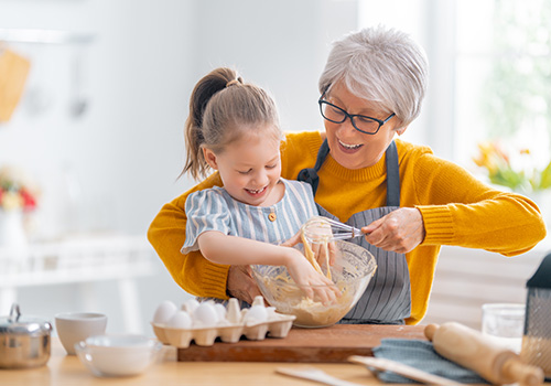 A grandmother baking with her granddaughter